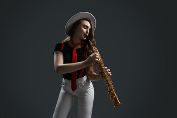 Obraz premium Musician playing soprano saxophone on grey background