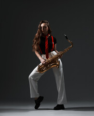 Fototapeta premium Professional musician with saxophone on grey background
