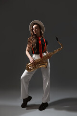 Naklejka premium Professional musician with saxophone on grey background