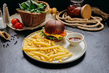 Gourmet burger with crispy fries and dipping sauce, served on plate in stylish restaurant setting