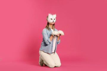 Quadrobics. Woman wearing cat mask and gloves on pink background