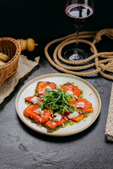 Roasted bell pepper carpaccio with arugula, feta cheese, pine nuts, and pesto, in gourmet style