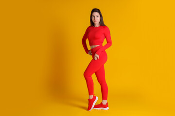 Portrait of woman in sportswear on orange background