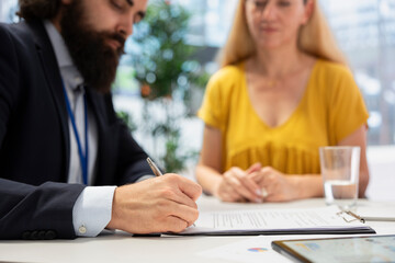 Fototapeta premium Financial advisor creating reports on investment performance and activity, filling paperwork forms. Close up shot of agent writing documents, developing portfolio maximizing financial gains