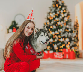 A happy girl with a dog and a tree celebrating Christmas