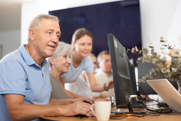 Obraz premium Curious mature man engaged in IT training during computer courses for adults