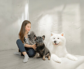 A young girl and her dog are smiling in a studio with lights and shadows, showing friendship and love.