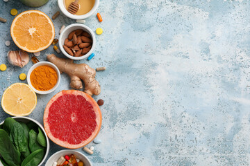 Composition with different healthy food and pills on color grunge background. Immunity boosting...