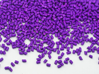 Purple masterbatch granules on white background, a polymer carrier for color pigments in the plastic industry. Perfect for plastic company catalog design