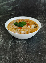 Soup in a white plate on a black background 