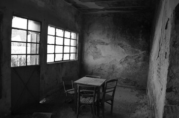 black and white photograph of the dining room of an abandoned rural house