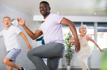 Group of multinational sports aged people rehearsing hip hop dance in dance hall