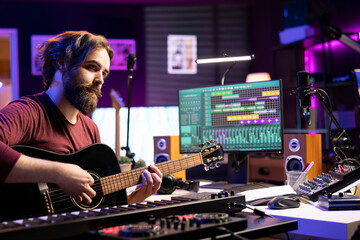 Professional artist teaching guitar lessons on social media web channel, recording himself playing musical instrument accords and explaining strings notes. Young songwriter making tutorials.