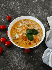 Soup in a white plate on a black background 