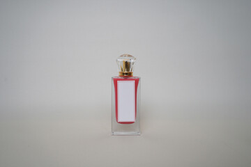Minimalist photo of a stylish perfume bottle with a gold cap and blank white label, standing...