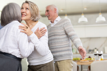 As two elderly woman meet, they exchange warm greeting by embracing with a gentle kiss on the cheek