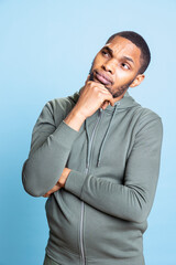 African american contemplative person thinking about new solutions against blue background,...