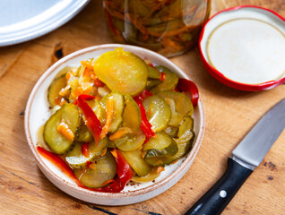 Pickled cucumbers and bell peppers in a glass jar