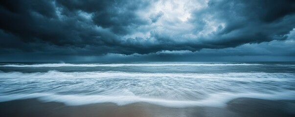 Dramatic thunderstorm clouds over turbulent ocean waves at sandy beach