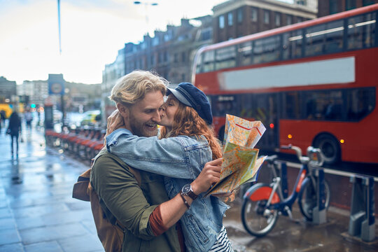 Young redhead couple smiling and exploring the city