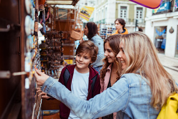 Happy mother and children shopping for souvenirs at a street market