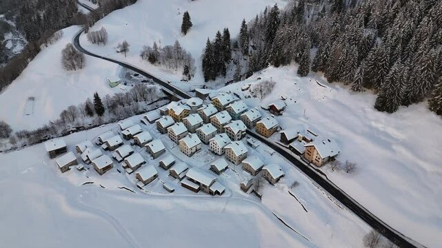 Aerial video above a small snowy village in winter in the Fontana val Bedretto Snow area
