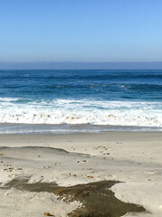 Sandy Beach with Gentle Waves and Bright Sky