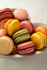 Macarons cookies in heart shaped plate, french macarons on bright background. Gift birth day, Valentine's day.