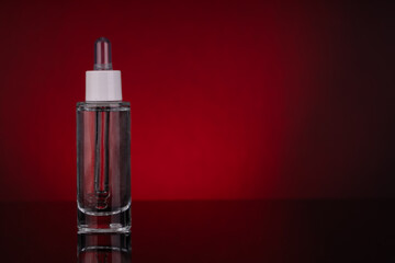Glass Dropper Bottle with Empty Space for Text on Red Background