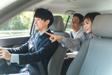 タクシーに乗り目的地を支持する乗客の夫婦