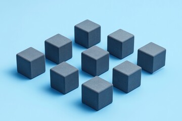 Obraz premium Nine dark gray cubes arranged in a grid pattern on a light blue background.