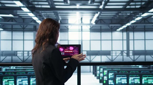 Data center engineers struggling to contain virus infestation, working on securing servers. Team of server farm employees detecting hacker attacks on tablet, fighting back, camera B