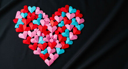 Happy Valentine's Day banner. Holiday background design with big heart made of pink, red and blue Origami Hearts on black fabric background. Horizontal poster, flyer, greeting card, header for website