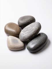 Smooth, polished stones of varying colors and sizes arranged on a white background.