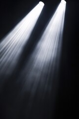 Three spotlights are illuminating a smoky, dark room