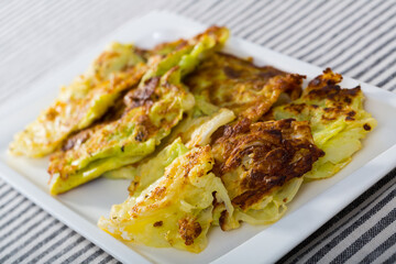 Image of tasty leaves of cabbage in batter on a plate at table