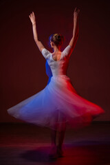 Fototapeta premium Caucasian woman dancing classical dance in tutu . Long exposure photo. 