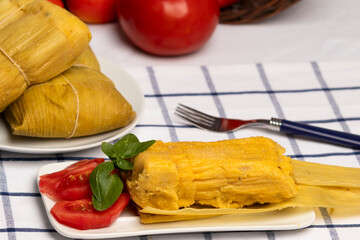 Humitas en hojas, plato típico Chileno en Verano, junto a ensalada de tomate decorada con unas...