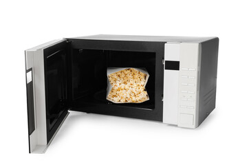 Open microwave oven with bag of popcorn isolated on white