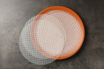 Edible rice paper sheets on grey textured table, top view