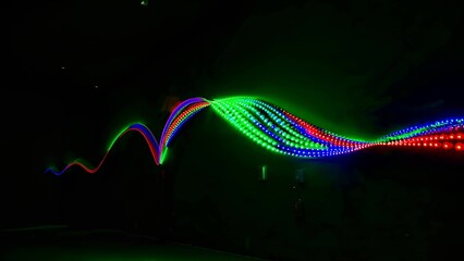 Dynamic display of multicolored led light waves forming vibrant patterns on a dark background, showcasing the beauty of modern technology and artistic design in an abstract form