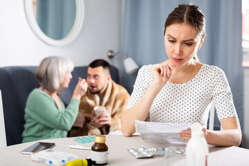 Fototapeta premium Young wife carefully reads the annotation for medicines and checks the information on the Internet
