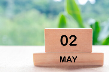 2 May text on wooden blocks with customizable space for text or messages. Month and copy space...