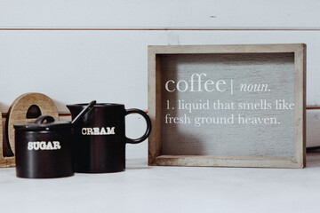 Kitchen with a framed sign saying &ldquo;COFFEE is a noun&rdquo; and the phrase &ldquo;Liquid that smells like fresh ground heaven&rdquo;