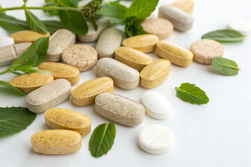 Obraz premium Herbal tablets scattered on a white background
