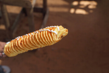 Spiral twisted tornado potatoes on a street foot market stall	
