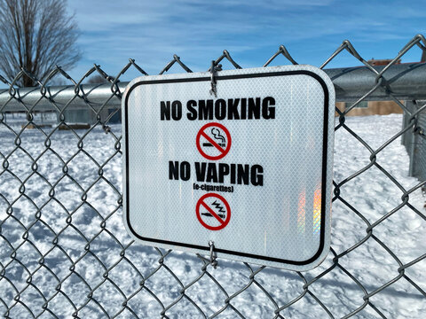No Smoking and No Vaping Sign on Chain-Link Fence in Snowy Area