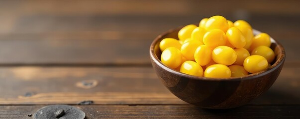 A bowl of yellow marble pebbles on a wooden surface, minimalist, simple, bowl