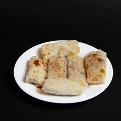Spring rolls on a white plate, serving portion
