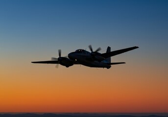 Obraz premium Twin Engine Airplane Silhouette at Sunset